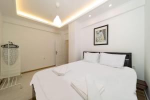 1 dormitorio con 1 cama blanca grande con almohadas blancas en Cozy en Antalya