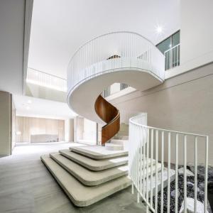 a spiral staircase in a building with a white stair case at Welladee Wellness Chiang Mai in Chiang Mai