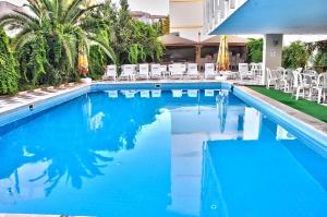 a large swimming pool with chairs and blue water at ROXX ROYAL HOTEL in Kuşadası