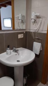 Un baño con lavabo, inodoro y espejo. en El Puentín del Sella con WiFi y parking gratuito, en Cangas de Onís 50 fotos más