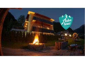 a fire pit in front of a house with a sign at Chalet Appartement Antonhaus E-Ladestation in Gaschurn