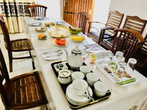 a table with dishes and a tea pot on it at Dambulla Tourist Resort in Dambulla