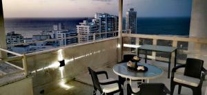 d'un balcon avec une table et des chaises donnant sur l'océan. dans l'établissement Penthouse 360 Cartagena, à Carthagène des Indes