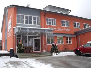 a red building with a red car parked in front of it at Pension Hüttendorf 49 gradnord in Bayerisch Eisenstein