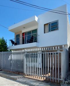 a white house with a white picket fence at Apartamento la Isla 1-Coveñas in Coveñas
