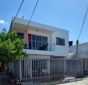a white house with a fence in front of it at Apartamento la Isla 1-Coveñas in Coveñas