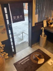 una puerta con un cartel delante de una puerta con madera en ゆいまーるEAST - Yuimaru East, en Kanazawa