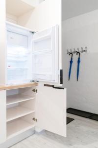 uma cozinha com um frigorífico aberto com pegas azuis em YouthMents - Student Hotel em Riga
