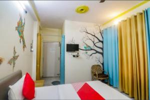 a bedroom with a bed with a tree mural on the wall at Om Shanthi paying guest house in Varanasi