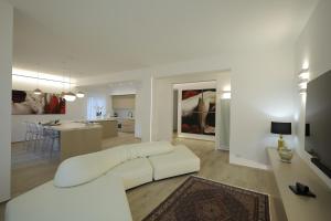 a living room with a white couch and a kitchen at Gonzaga Guest House in Naples