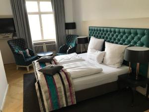 Schlafzimmer mit einem großen Bett mit einem grünen Kopfteil in der Unterkunft Schloss Höhenried in Bernried