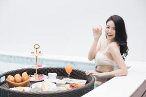 a woman sitting at a table with a tray of food at VEVILLA in Bangkok