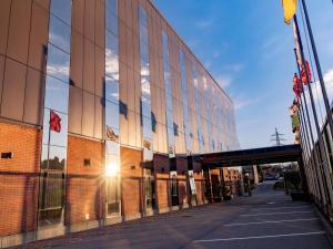 a building with a reflection of the sun in the windows at Hotel Coronado in Mendrisio