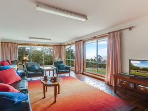 a living room with a couch and a tv at Captain's Lookout in Bellawongarah
