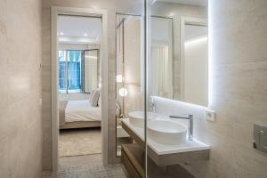 łazienka z umywalką, lustrem i łóżkiem w obiekcie Casona Seis Lunas Apartment w Marbelli