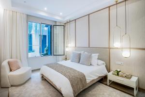 马贝拉Casona Seis Lunas Apartment的一间卧室，里面有一张床、一把椅子和一扇窗户