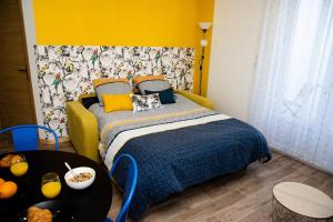 1 dormitorio con 1 cama con pared amarilla en L'Amarillo Clim Wifi Centre ville 4 pers, en Lézignan-Corbières