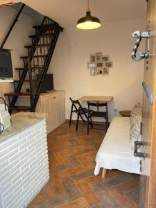 Habitación con escalera y mesa con sillas. en Casita Beatriz - by Casa del Patio en Estepona