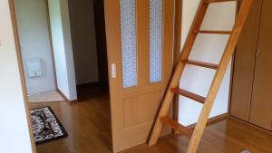 um quarto com uma porta de madeira e uma escada em Crane / Vacation STAY 564 em Kunisaki