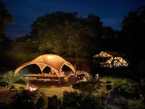 a picnic table with a tent in a garden at night at Ecostay Glamping Rainbow Forest in Ishigaki Island