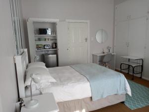 a bedroom with a white bed and a table and a lamp at Innes Road Durban Accommodation Private Double Room with Private Bathroom in Durban
