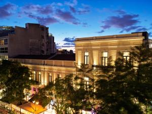 un bâtiment éclairé dans une ville la nuit dans l'établissement NLH MONASTIRAKI - Neighborhood Lifestyle Hotels, à Athènes