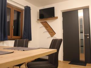 a dining room with a table and a tv on the wall at Ferienwohnung an der Jodquelle in Bad Endorf