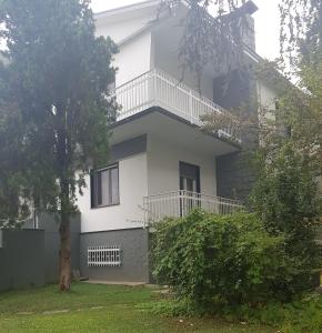 ein weißes Haus mit einem Balkon und einem Hof in der Unterkunft Residenza Villa Cristalli in Piacenza