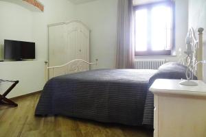 a bedroom with a bed and a tv and a window at Agriturismo Giugnano Poggio del Sole, Lamporecchio in Lamporecchio