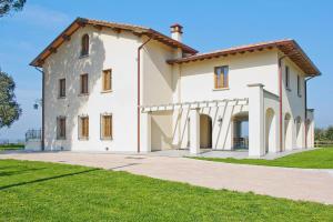 una gran casa blanca con césped en Agriturismo Giugnano Poggio del Sole Lamporecchio, en Lamporecchio