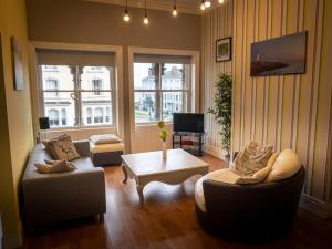 a living room with two couches and a coffee table at Cornerhouse Apartments Llandudno in Llandudno