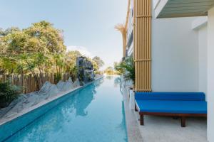 a blue bench sitting next to a swimming pool at Baan Taranya Koh Yao Yai Resort in Ko Yao Yai +56 photos