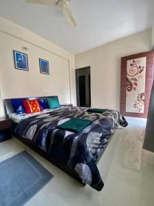 1 dormitorio con 1 cama grande y almohadas coloridas en 1 BHK flat with Free Wi Fi Kitchen en Pune