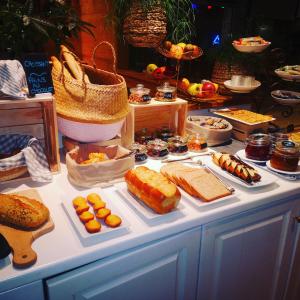 a table with many different types of bread and pastries at Le Konine - Hotel & Bar & Restaurant in Montceau-les-Mines