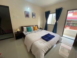 a bedroom with a large bed with blue curtains at 1 BHK flat with Free Wi Fi Kitchen in Pune
