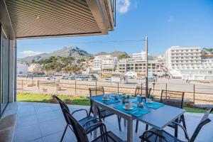 a table and chairs on a patio with a view of a city at Mirador Blue G in Cala de Sant Vicenc