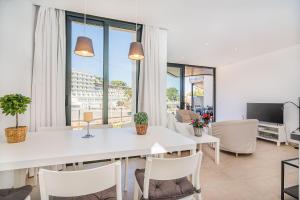 a living room with a white table and chairs at Mirador Blue G in Cala de Sant Vicenc