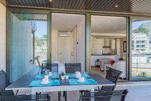 a dining table and chairs in a house at Mirador Blue G in Cala de Sant Vicenc