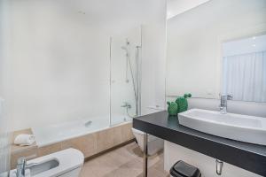 a white bathroom with a sink and a toilet at Mirador Blue G in Cala de Sant Vicenc +16 photos