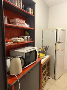 eine Küche mit einer Mikrowelle und einem Kühlschrank in der Unterkunft Maison de 2 chambres a Clion in Clion