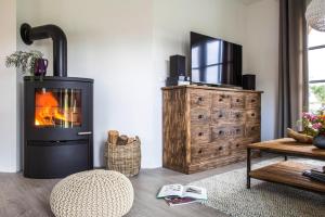 a living room with a fireplace and a television at Holiday house, Fuhlendorf in Fuhlendorf