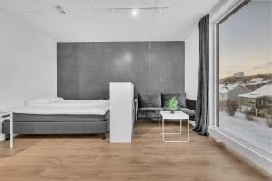 Un dormitorio con una cama, un sofá y una mesa. en TotalApartments Stakkevollvegen Studio, en Tromsø