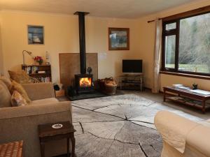 a living room with a couch and a fireplace at Rose Cottage in Acharacle