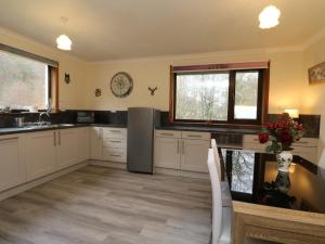 une cuisine avec des placards blancs et un comptoir dans l'établissement Rose Cottage, à Acharacle