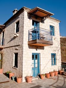 un edificio con una puerta azul y un balcón en Napoleon Zaglis Guesthouse, en Kalarites