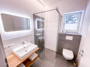 ein Badezimmer mit Dusche, Waschbecken und Toilette in der Unterkunft Glüxplatzl GmbH Appartements am Wald in Sankt Martin am Tennengebirge + 25 Fotos