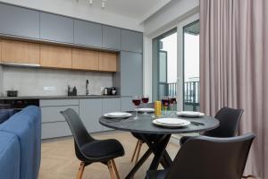 a dining room with a table and chairs and a kitchen at Mokotów Apartment LUX with Parking by Renters Prestige in Warsaw