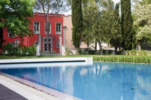 una gran piscina azul frente a una casa roja en Residence Villa Il Palagio, Rignano sull" Arno, en Rignano sullʼArno