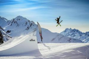 a snowboarder is in the air over a snow covered mountain at Apartment in Ischgl overlooking the mountains in Ischgl