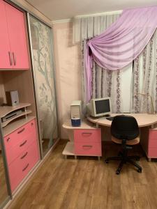 a room with a desk with a computer and pink cabinets at Приватний будинок з сауною та більярдом in Khashchevoye